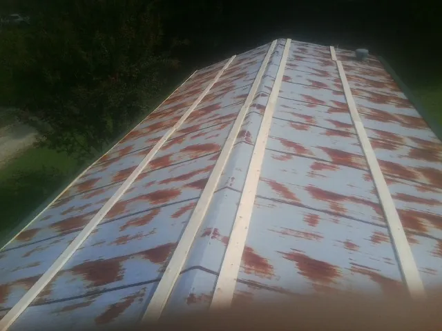 Rusted metal roof panels with new wood purlins before replacement — Storm Damage Roof Repair in Rembert by Roofing Brothers