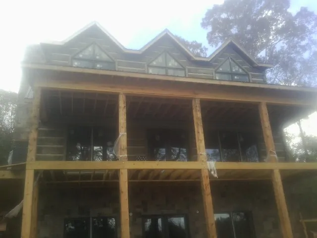 Dormers and porch framing on a large log home under construction — Roof Coating work by our crew in Rembert