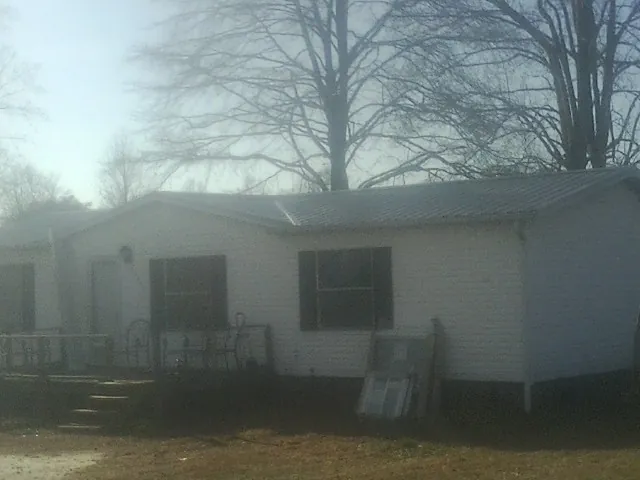 New metal roof on a white painted brick home on a foggy morning in Rembert