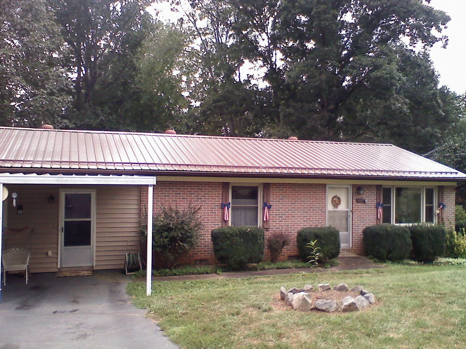 Bronze metal roof and carport on a brick ranch home — Roof Repair work by our crew in Rembert